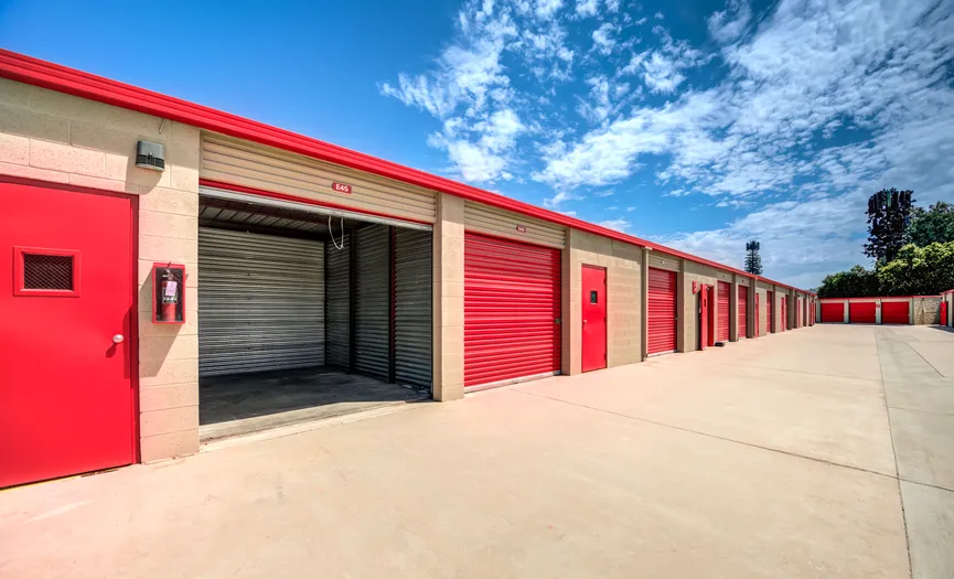 Drive-up storage units with doors open showing interior space at a secure storage facility in Moreno Valley
