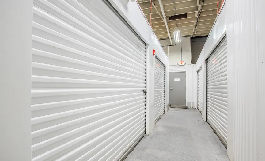 Clean hallway of indoor self storage units inside a secure storage facility